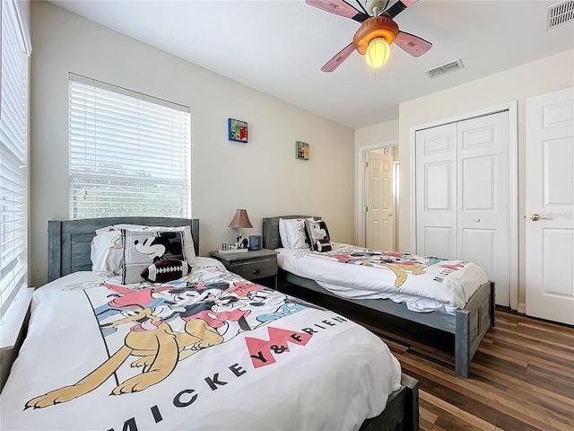 bedroom featuring dark hardwood / wood-style flooring, ceiling fan, and a closet