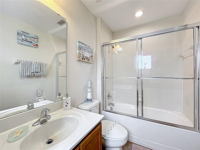 full bathroom featuring vanity, toilet, and bath / shower combo with glass door