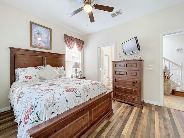 bedroom featuring ensuite bath, hardwood / wood-style floors, and ceiling fan