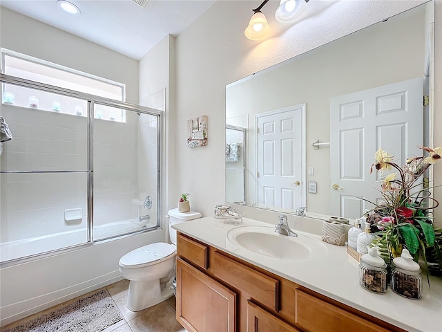 full bathroom with vanity, toilet, bath / shower combo with glass door, and tile patterned floors