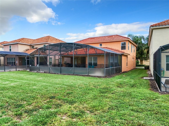 rear view of property featuring glass enclosure and a yard