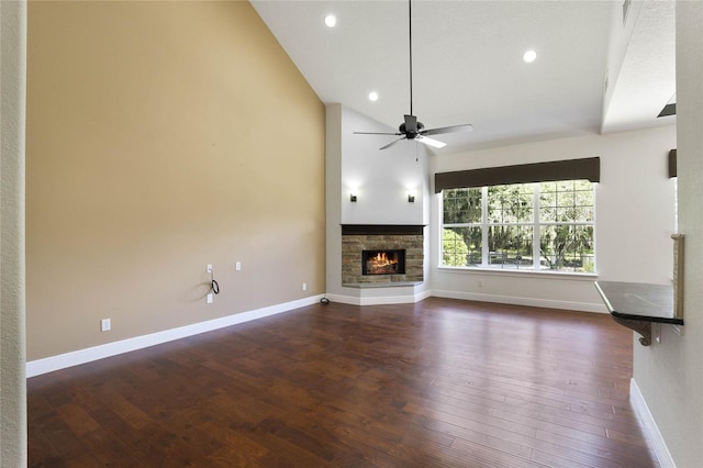 unfurnished living room with dark wood-style flooring, a fireplace, baseboards, and ceiling fan