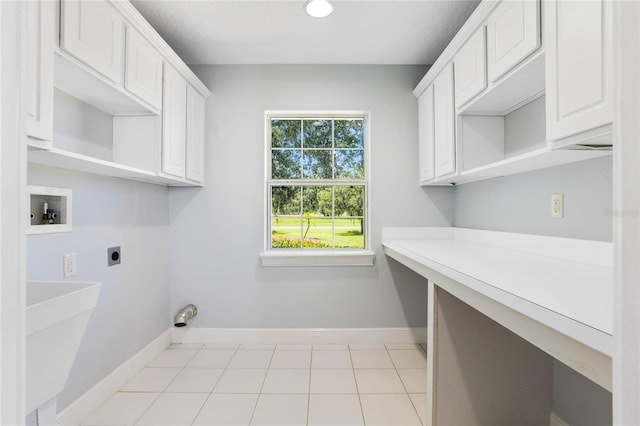 laundry area with hookup for a washing machine, cabinet space, light tile patterned flooring, electric dryer hookup, and baseboards