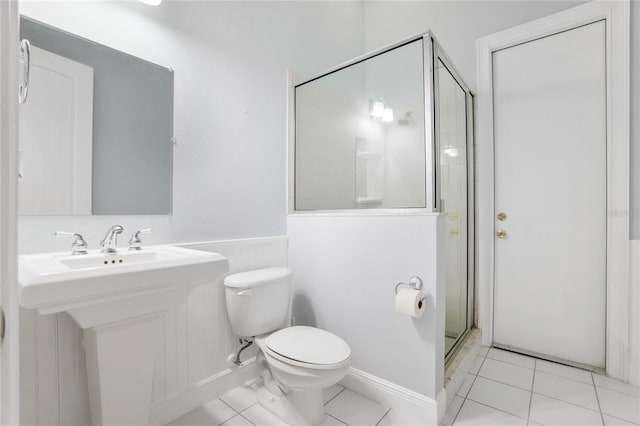 full bathroom featuring toilet, a wainscoted wall, a shower stall, and a sink