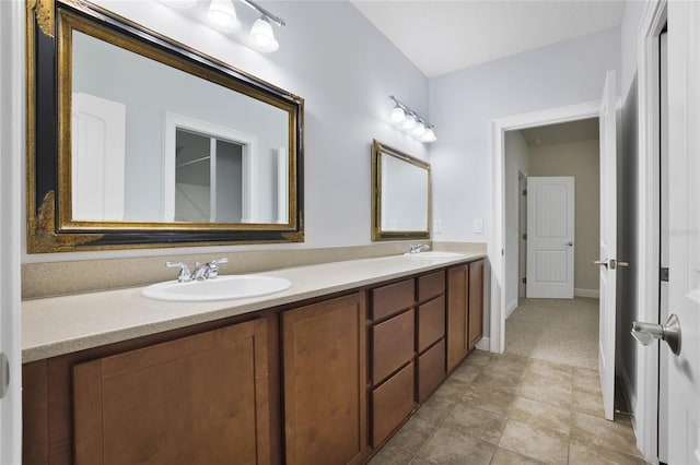 bathroom featuring a sink, baseboards, and double vanity