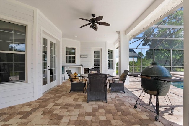 view of patio featuring ceiling fan, glass enclosure, outdoor dining area, french doors, and an outdoor pool