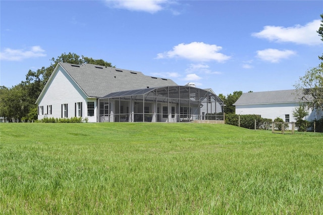 rear view of house with a yard and glass enclosure