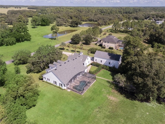 drone / aerial view featuring a water view and a forest view