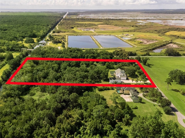 aerial view with a water view and a wooded view