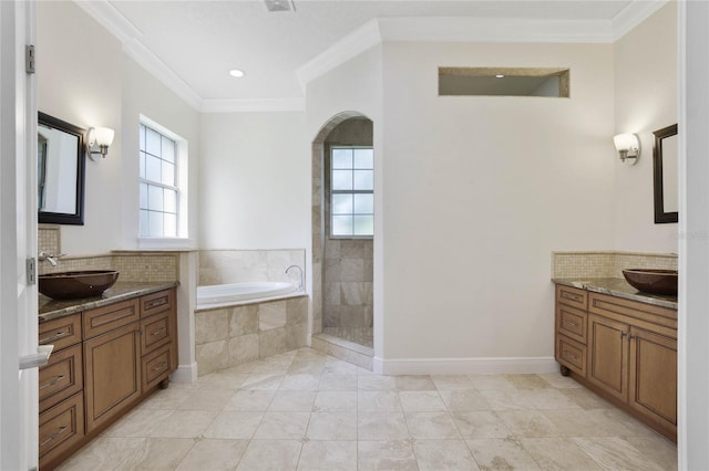 bathroom with a bath, a sink, a wealth of natural light, and crown molding