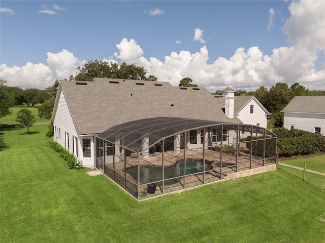 rear view of property featuring roof with shingles, a patio, a chimney, glass enclosure, and an outdoor pool