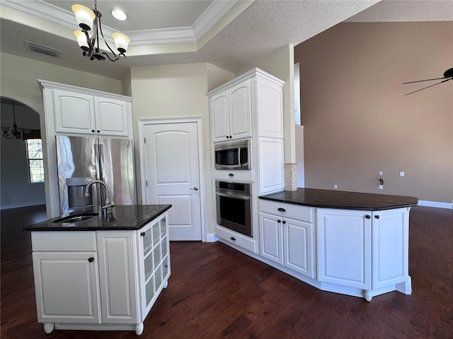 kitchen featuring a raised ceiling, visible vents, appliances with stainless steel finishes, a sink, and a peninsula