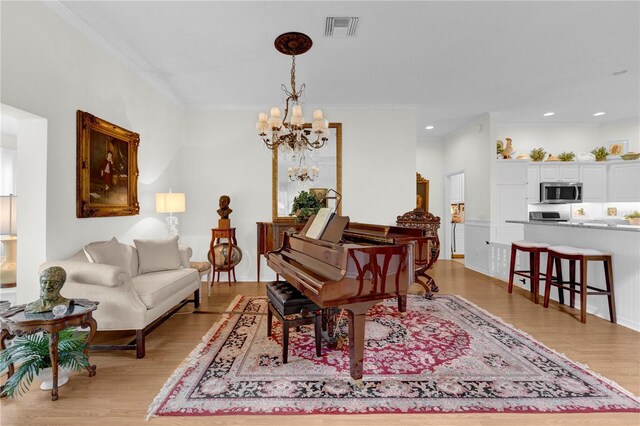 interior space with a notable chandelier, crown molding, and light hardwood / wood-style flooring