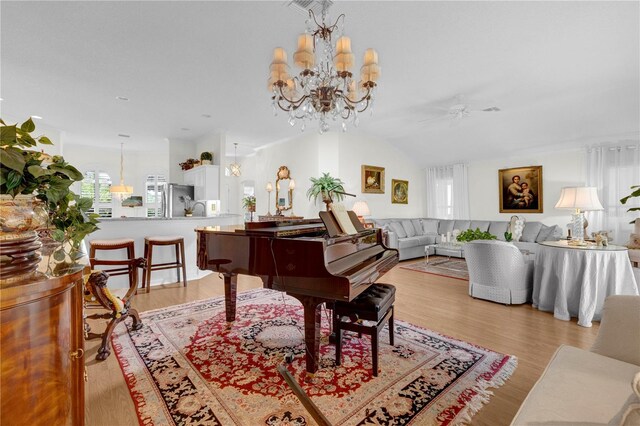 misc room featuring light wood-type flooring, lofted ceiling, and an inviting chandelier