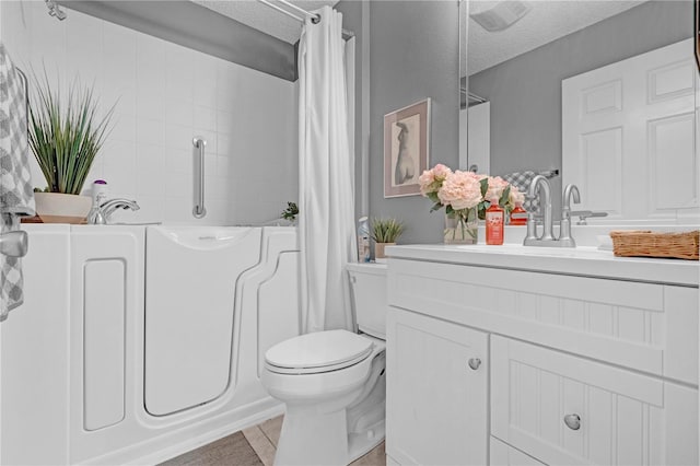 full bathroom with a textured ceiling, vanity, shower / tub combo, tile patterned flooring, and toilet