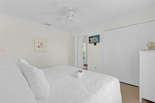 bedroom with a closet, ceiling fan, a textured ceiling, and ornamental molding