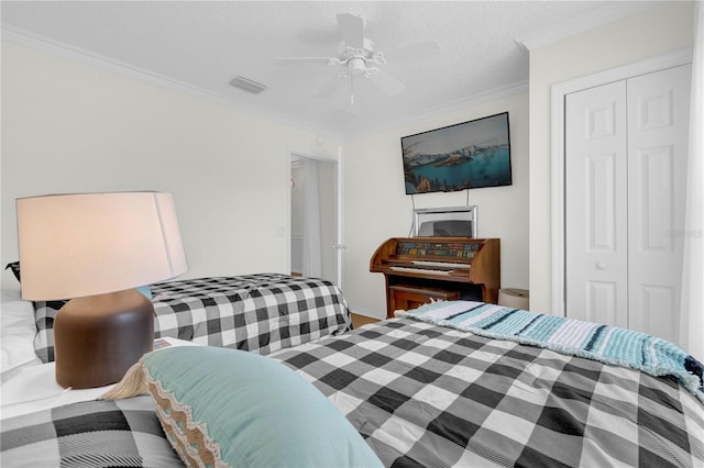 bedroom with a closet, ceiling fan, a textured ceiling, and ornamental molding