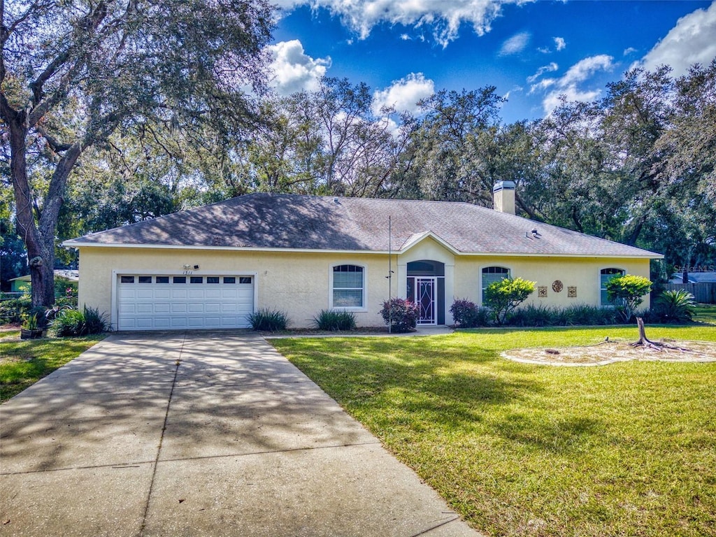 single story home featuring a front lawn and a garage