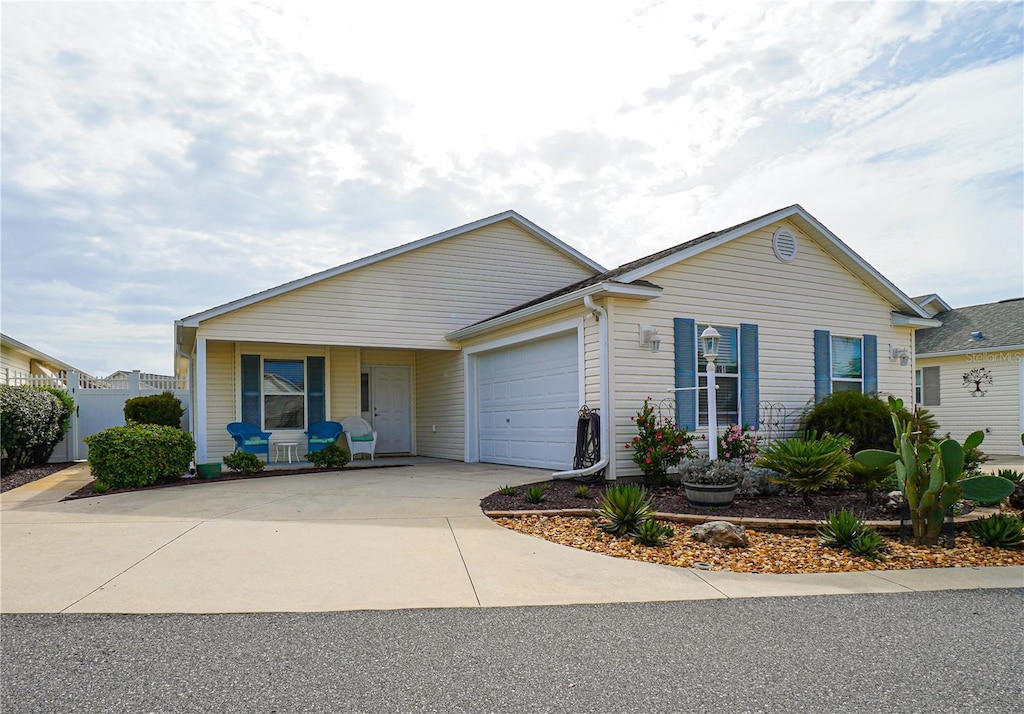 ranch-style home featuring a garage, driveway, and covered porch