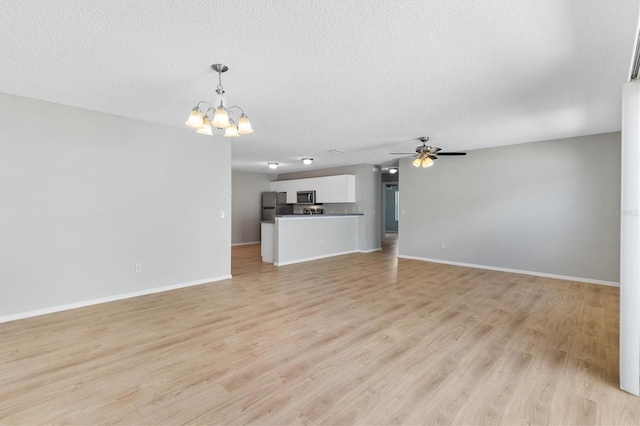 unfurnished living room with a textured ceiling, ceiling fan with notable chandelier, and light hardwood / wood-style floors