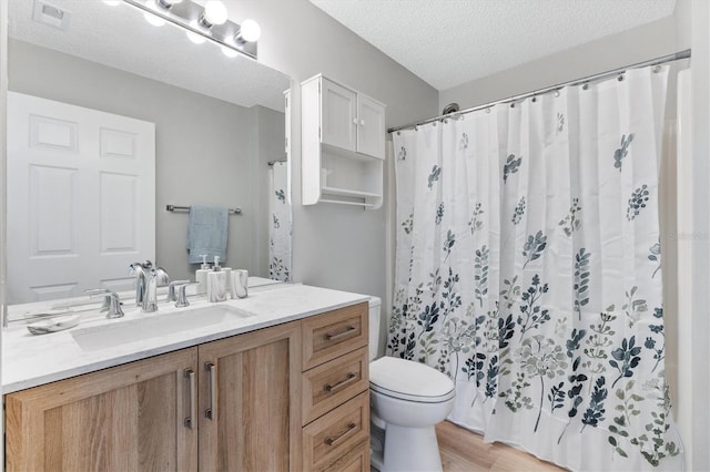 bathroom with toilet, vanity, hardwood / wood-style flooring, a textured ceiling, and a shower with shower curtain