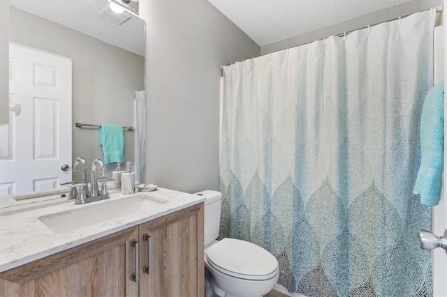 bathroom featuring a textured ceiling, vanity, toilet, and curtained shower