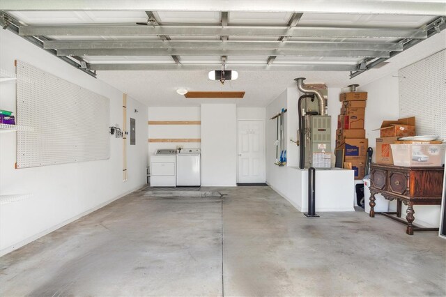 garage with electric panel, heating unit, and washer and clothes dryer