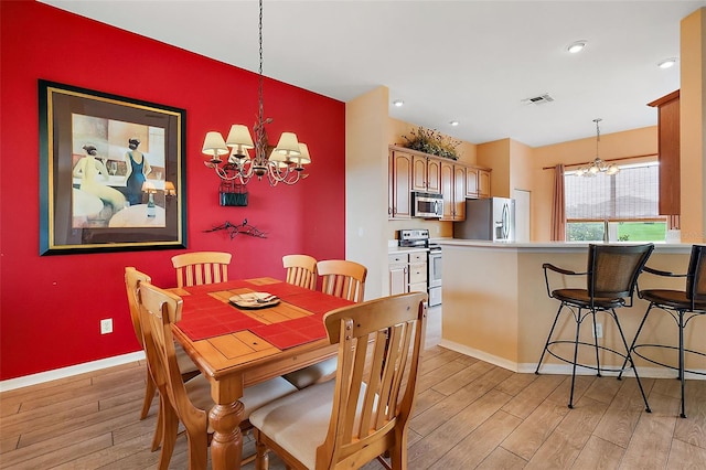 dining room with an inviting chandelier and light hardwood / wood-style floors