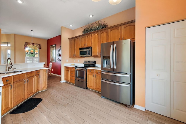 kitchen with light hardwood / wood-style floors, pendant lighting, stainless steel appliances, an inviting chandelier, and sink