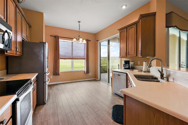 kitchen with light hardwood / wood-style floors, sink, stainless steel appliances, and plenty of natural light