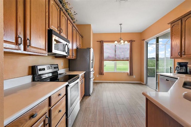 kitchen with light hardwood / wood-style flooring, stainless steel appliances, a chandelier, and a healthy amount of sunlight