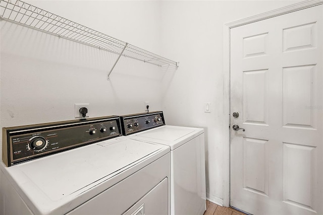 clothes washing area featuring light hardwood / wood-style floors and washer and dryer