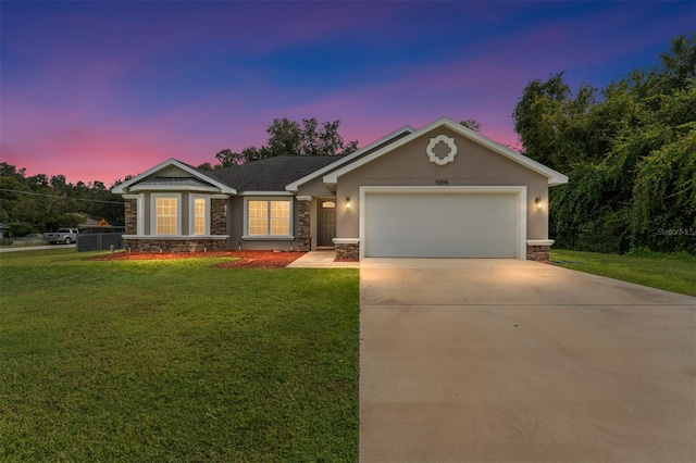 ranch-style home featuring a lawn and a garage