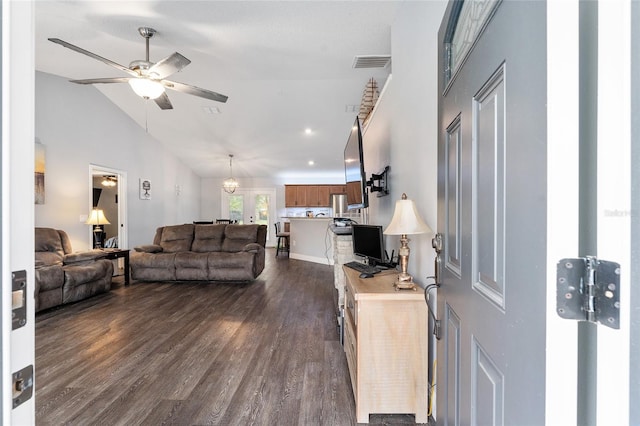 living room featuring vaulted ceiling, dark hardwood / wood-style flooring, and ceiling fan