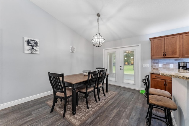 dining area with lofted ceiling, french doors, dark hardwood / wood-style floors, and an inviting chandelier