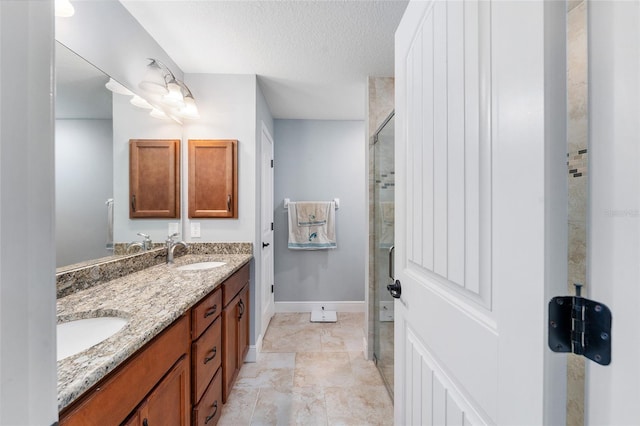 bathroom with vanity, a textured ceiling, and an enclosed shower