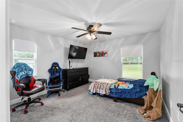 bedroom with ceiling fan, a textured ceiling, and carpet floors