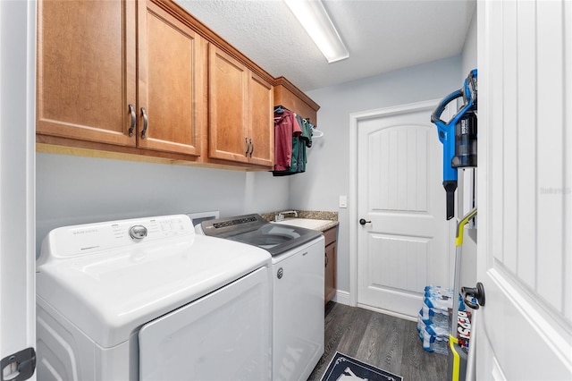 laundry room with sink, washer and dryer, dark hardwood / wood-style floors, cabinets, and a textured ceiling