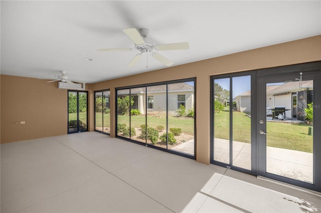 unfurnished sunroom featuring ceiling fan