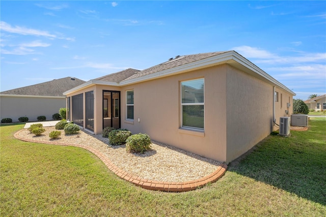 back of property with a sunroom and a lawn