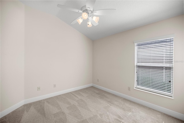 carpeted empty room featuring ceiling fan and vaulted ceiling