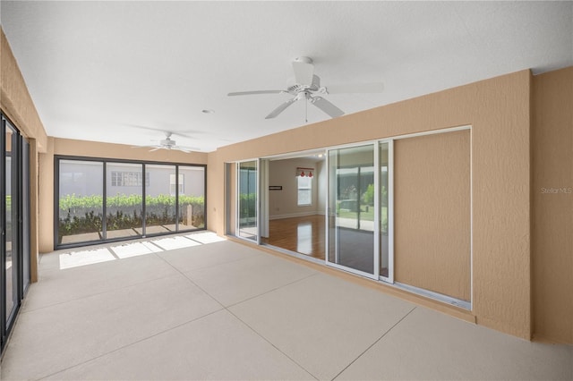 unfurnished sunroom with ceiling fan