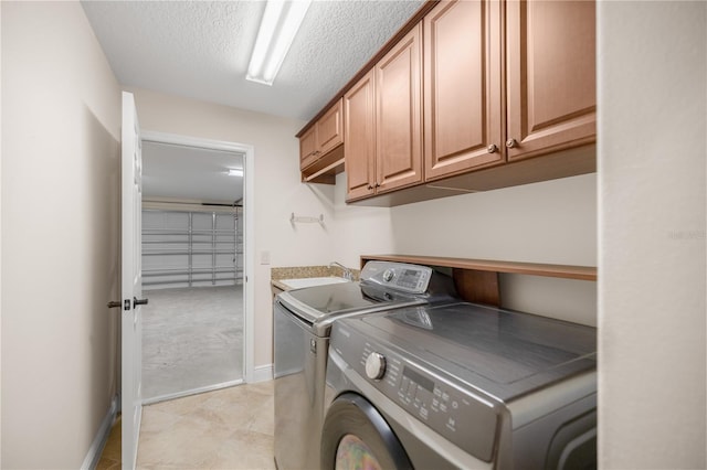 laundry room featuring sink, a textured ceiling, separate washer and dryer, and cabinets