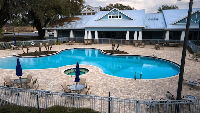 view of swimming pool featuring a patio and a hot tub