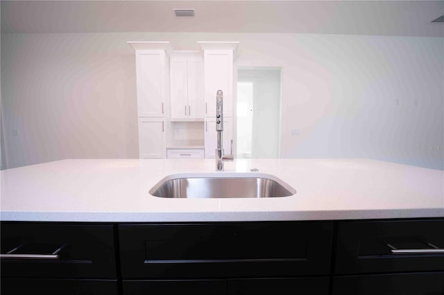 kitchen featuring white cabinetry and sink