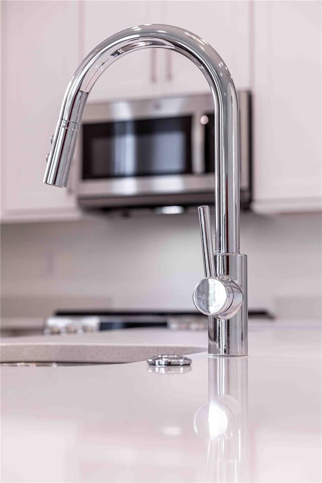 details with white cabinets and sink