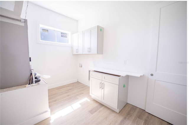 laundry room featuring cabinets, hookup for a washing machine, and light hardwood / wood-style flooring