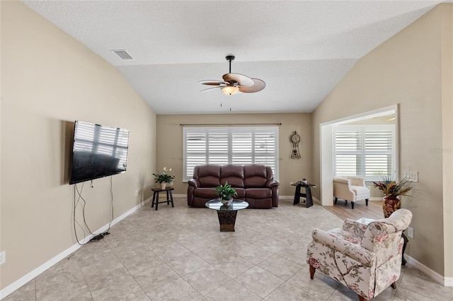 living area with visible vents, baseboards, light tile patterned floors, ceiling fan, and vaulted ceiling