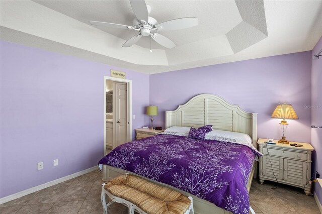 tiled bedroom featuring ceiling fan and a raised ceiling