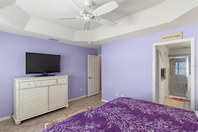 bedroom featuring a tray ceiling, light tile patterned floors, baseboards, and visible vents